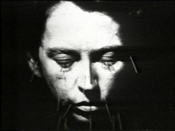 face closing eyes against black background