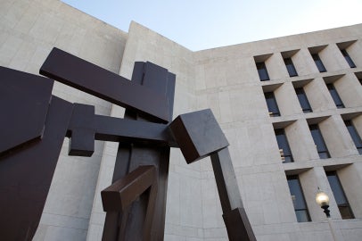 flat brown surface sculpture up against limestone building