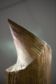 textured wooden shape curving to left against gray background