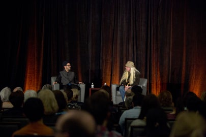 two people sitting on stage facing each other
