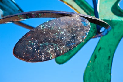 Red and green curvy surface with blue sky in background