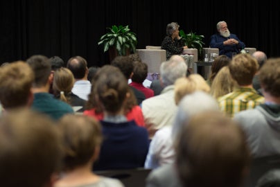 crowd sitting looking at two people on stage