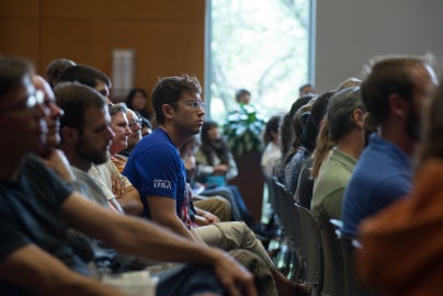 person leaning forward out of row of people looking forward