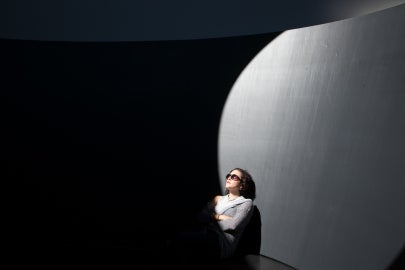 person sitting in sunlight looking up with sunglasses on 