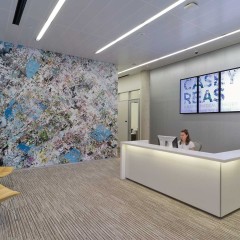A large digital mural with a woman behind an administrative desk