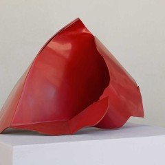 A red sculpture on a pedestal 