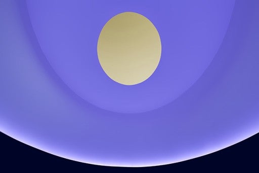 Purple walls with an oculus revealing a yellow sky in the James Turell Skyspace