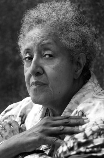 A black and white headshot of an older black woman with her arms crossed on her chest.
