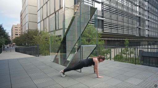 A woman in a plank position in front of mirrored work of art
