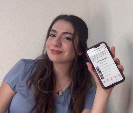 photo of a girl holding an iphone with the Landmarks app featured on the screen