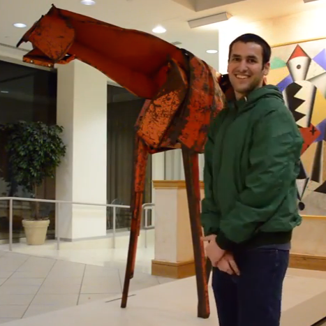 A man standing in front of a horse sculpture