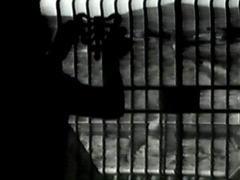 Charlemagne Palestine, Body Music I/Body Music II, 1973–74 A man putting a bow-like object on a gate