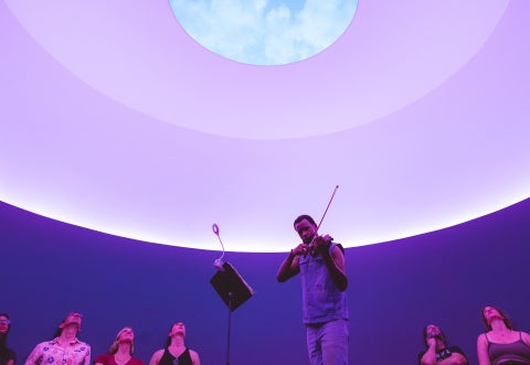 A musician performing inside James Turrell's "The Color Inside"