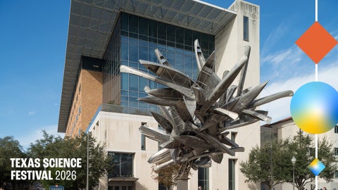 A suspended sculpture of steel and aluminum canoes in front of a building.