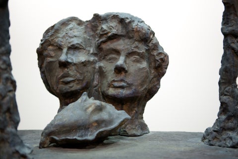 a bronze bust of two heads with a bronze conch in the foreground