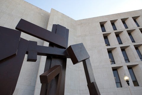 flat brown surface sculpture up against limestone building