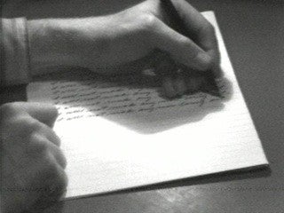 A person writing on a piece of paper.