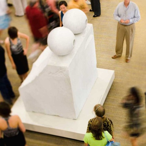 A large marble sculpture with people walking around it