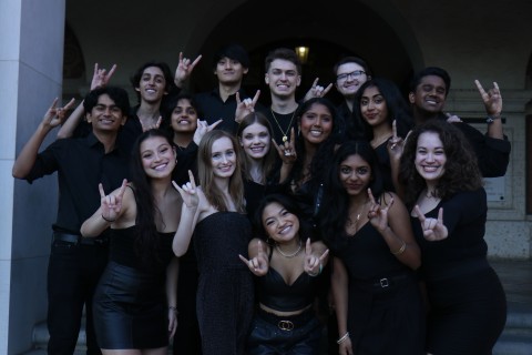 A photo of Noteworthy A Cappella holding up the Longhorn "Hook Em"