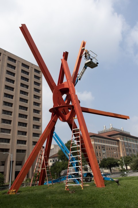 A cherry picker and ladders surround Mark di Suvero's sculpture "Clock Knot."