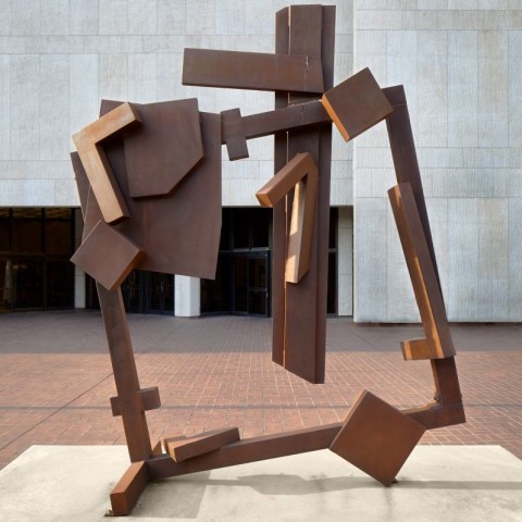 A steel sculpture that has elements welded to a main square frame which has been slightly tilted