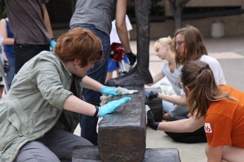 students waxing a bronze sculpture
