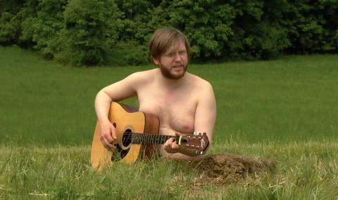 man playing guitar in field